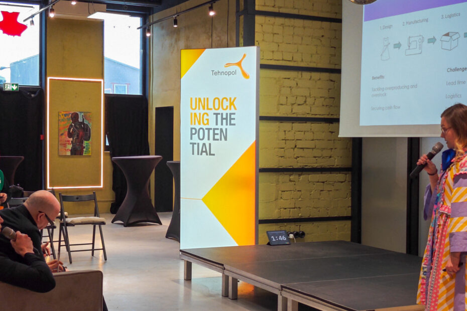 woman giving a pitch in front of an audience and a jury.